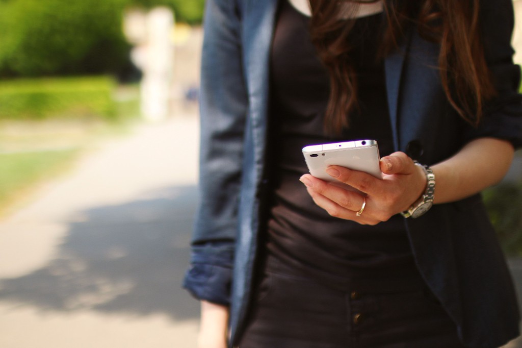 Kundin mit Smartphone – Pflege-Abos und Termine online buchen